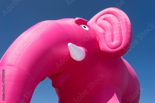 Inflatable pink elephant on a background of blue sky