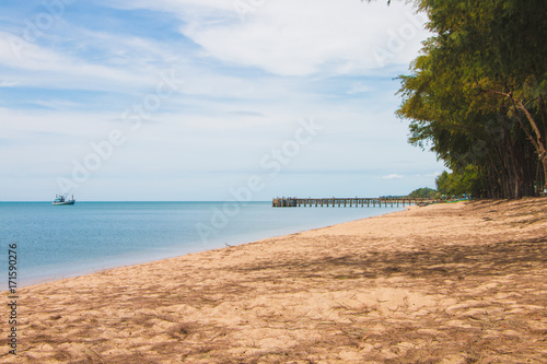 Sea landscape view on the beach with boat and jetty bridge