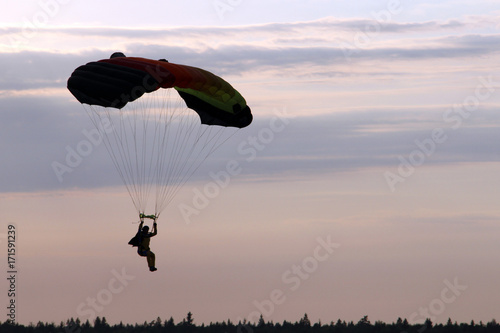 View to parachutist flying in the evening sky.