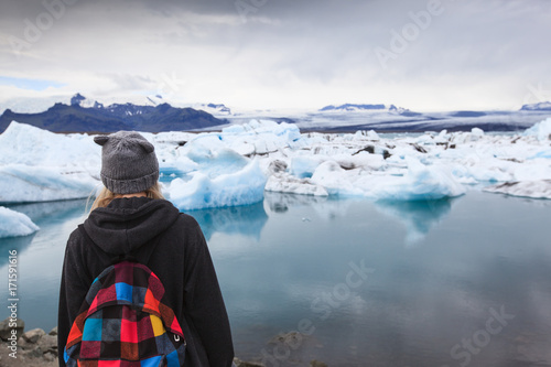 Back view of traveler young girl with backpack. Glacier lagoon Jokulsarlon, Iceland 