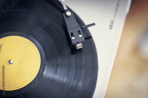 Top view of a turntabel record player showing a black vinyln with a yellow lable