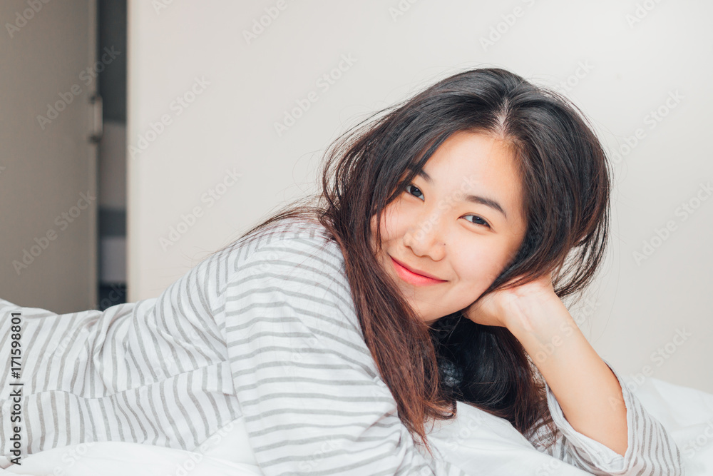 Pretty young asia woman smilling and looking at camera on the bed Pretty young asia woman smilling and looking at camera on the bed