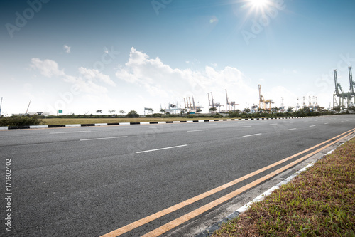 empty asphalt road with cranes in sunny day