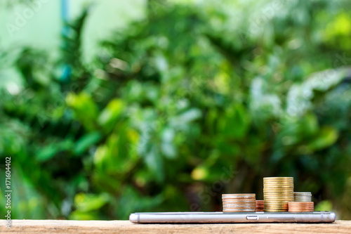 smart phone with stack of coins on top. business finance concept photo