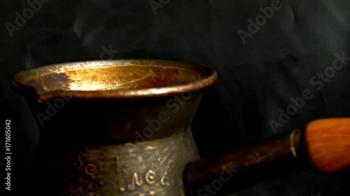 Fragrant coffee grains in turk. Delicious aromatic drink. Dark background