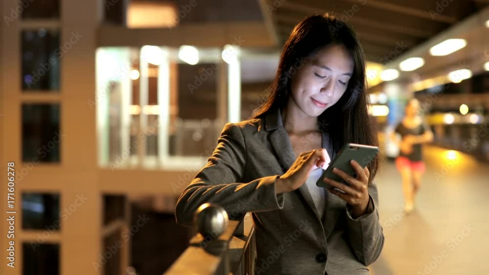 Business woman using smart phone in city at night Business woman using smart phone in city at night