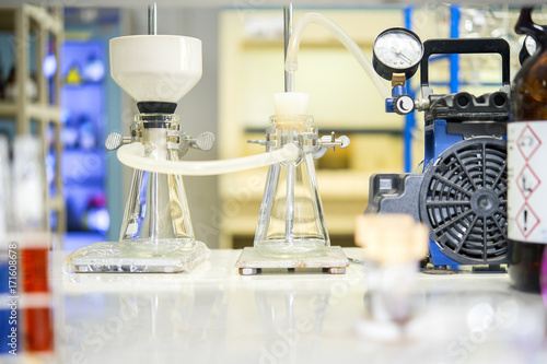 Chemical filtration with Buchner funnel bushings using a vacuum pump, in chemical laboratories.