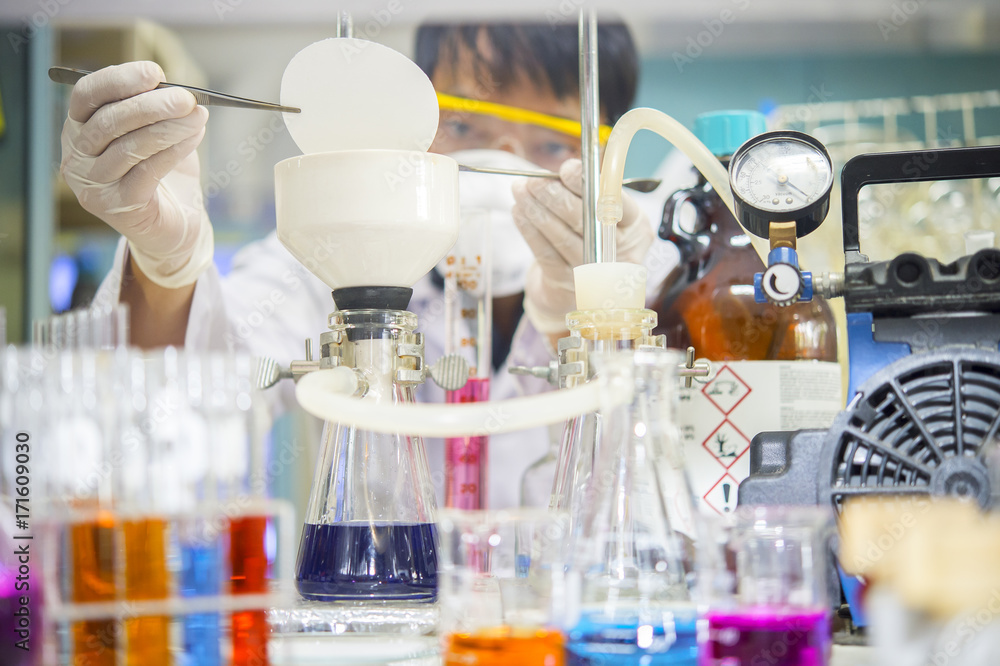 Scientists are using a filter clamp in a buchner funnel for chemical