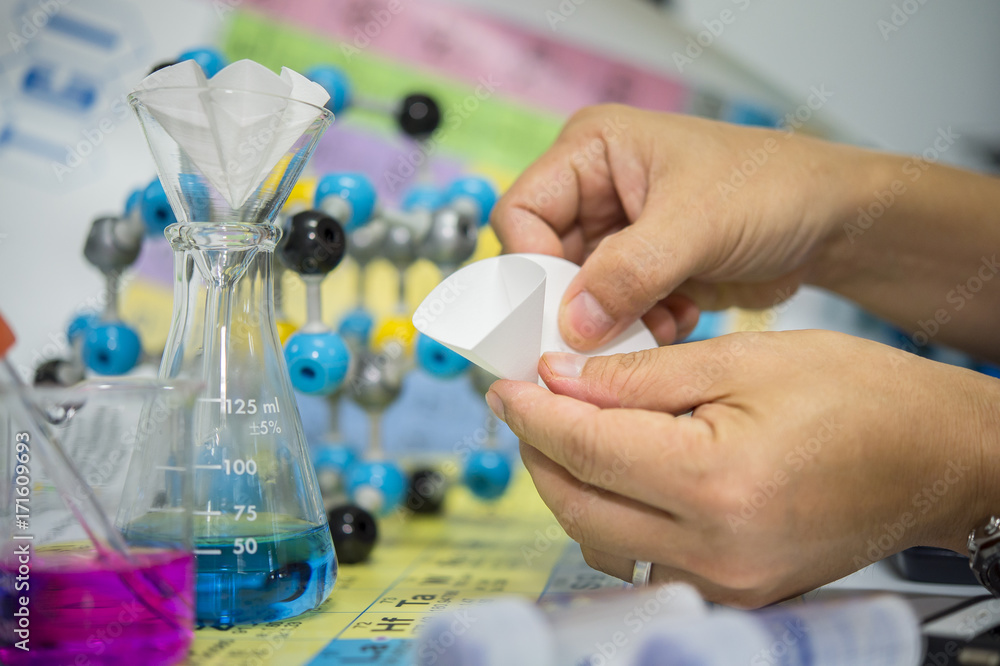 Scientists are folding filter paper for use in chemical filtration