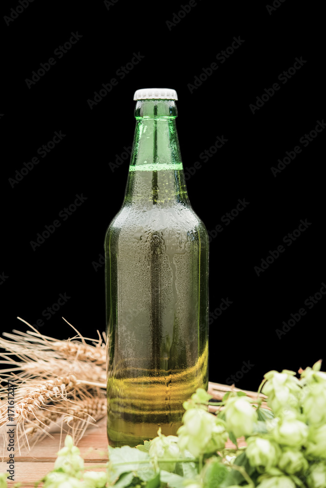 bottle of beer with hop and wheat and a glass