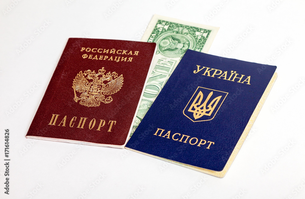 Ukrainian and Russian passports with one american dollar on the white background