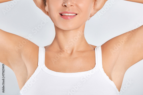 Beautiful young woman on light background. Concept of using deodorant