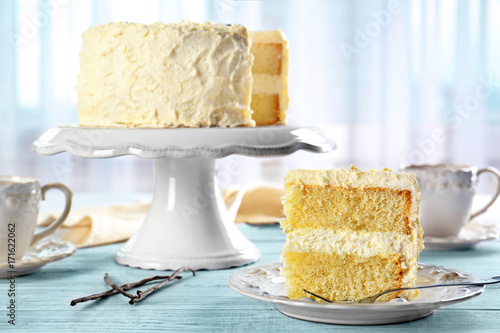 Delicious sliced vanilla cake on wooden table