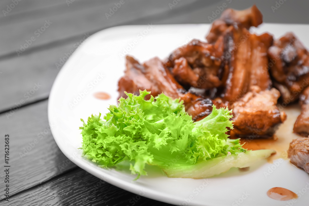 Delicious ribs served with salad on dinner table Delicious ribs served with salad on dinner table