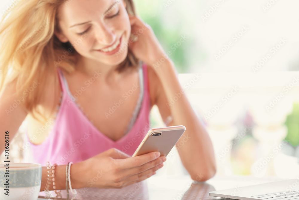 Beautiful young woman with mobile phone in cafe Beautiful young woman with mobile phone in cafe