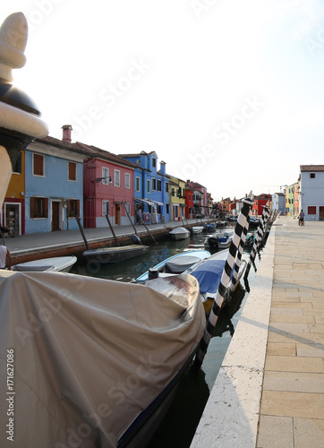 Fotografie, Obraz Boats moored in the navigable canal of Burano island near Venice