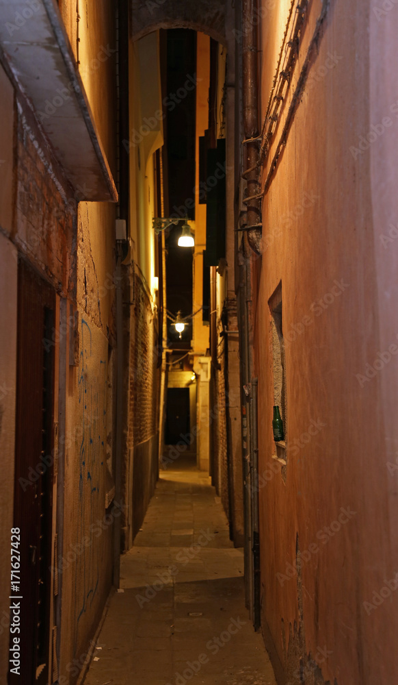 narrow venice street called CALLE in Italian at night with a lam