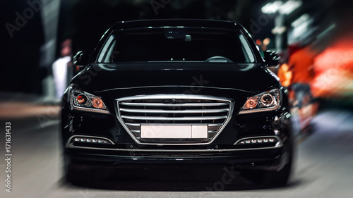 Black car of the luxury class in the city street. Front view, with blurred background   © jack_less
