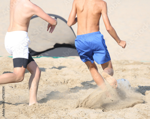 many athletes during the beach soccer game on the hot sand