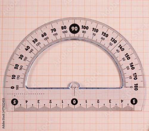 Close-up of a protractor on  graph paper