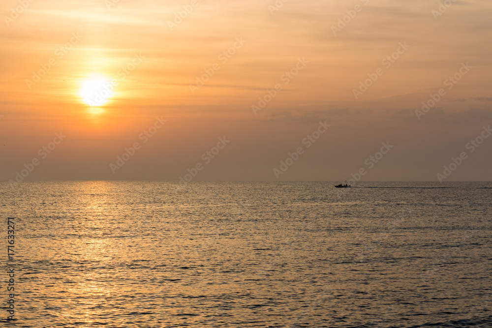 Obraz premium sunrise over the mediterranean sea with patrol boat