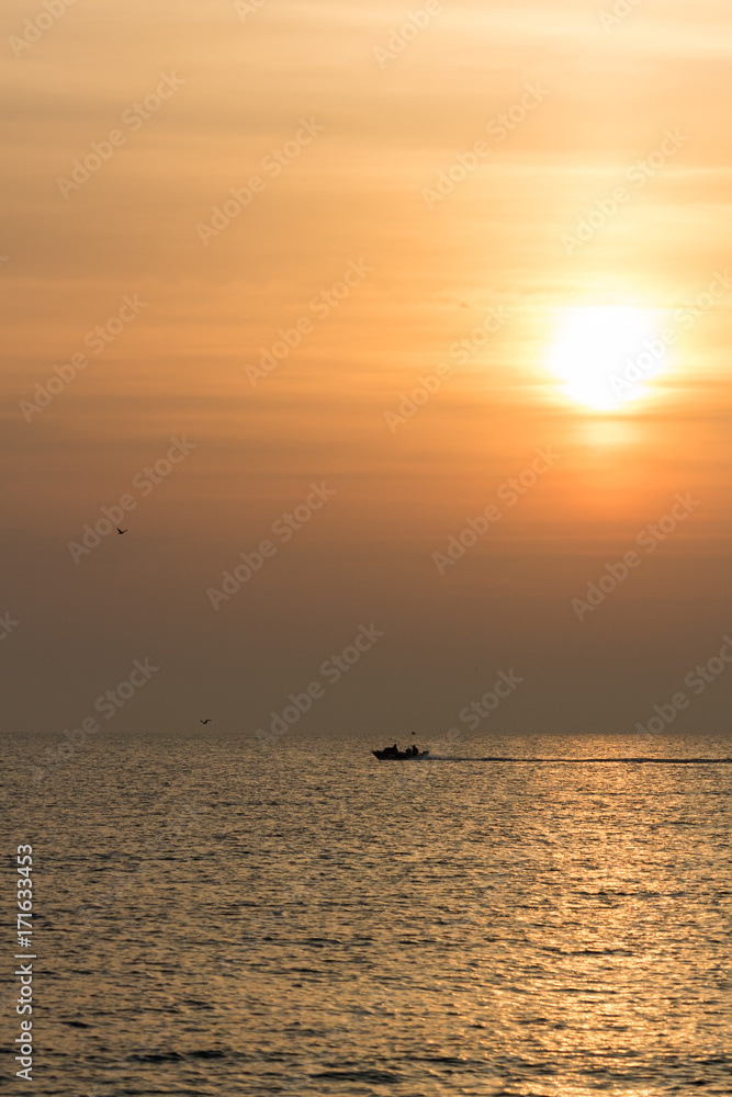 portrait of sunrise over the mediterranean sea with patrol boat and birds