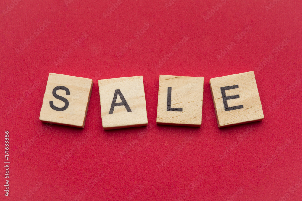Sale word on scrabble wooden tiles isolated on red background Sale word on scrabble wooden tiles isolated on red background