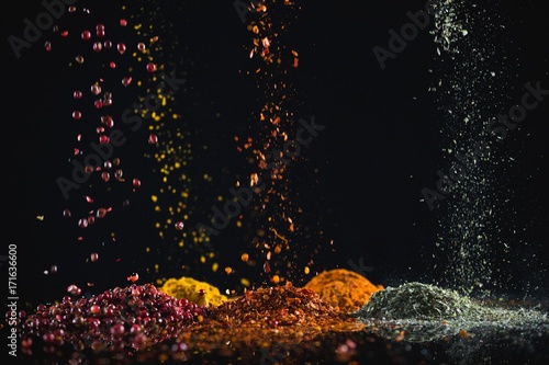 Fototapeta Naklejka Na Ścianę i Meble -  Powdered spices against black background