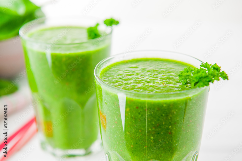 Fresh green Spinach smoothies in glass on the white wooden background. Healthy lifestyle concept. Selective focus. Backlight. Copy space. Fresh green Spinach smoothies in glass on the white wooden background. Healthy lifestyle concept. Selective focus. Backlight. Copy space.