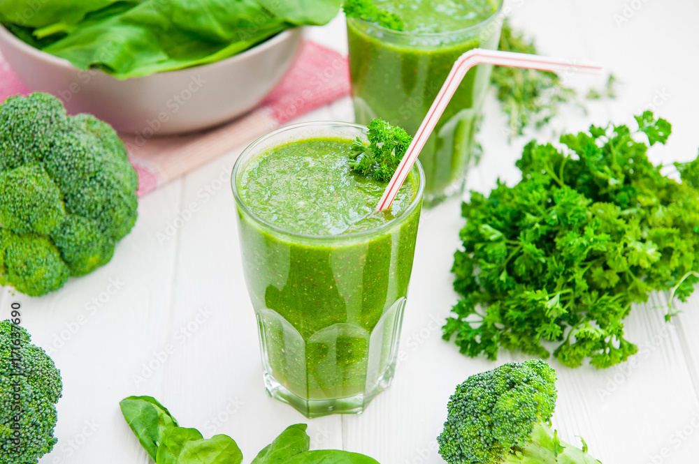 Fresh green Spinach smoothies in glass on the white wooden background. Healthy lifestyle concept. Selective focus. Backlight. Copy space. Fresh green Spinach smoothies in glass on the white wooden background. Healthy lifestyle concept. Selective focus. Backlight. Copy space.