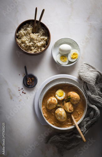 Egg curry in a ceramic bowl on top view photo