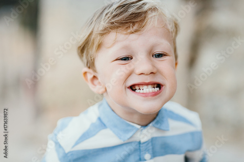 Cute little boy grinning and showing his teeth photo