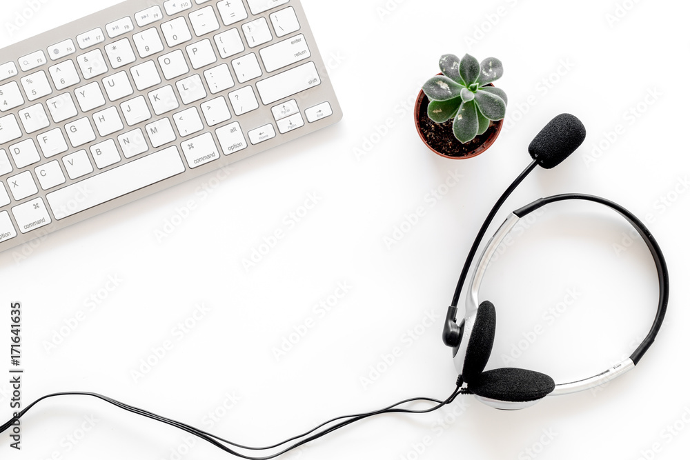 Workplace in call center. Headphones on keyboard on white background top view copyspace Workplace in call center. Headphones on keyboard on white background top view copyspace