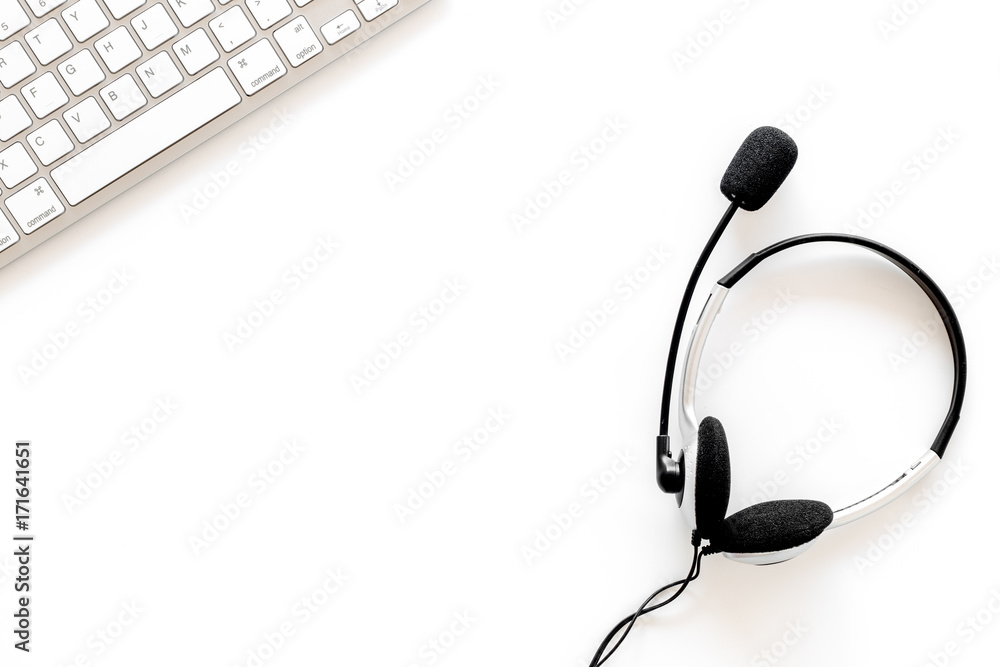 Workplace in call center. Headphones on keyboard on white background top view copyspace Workplace in call center. Headphones on keyboard on white background top view copyspace