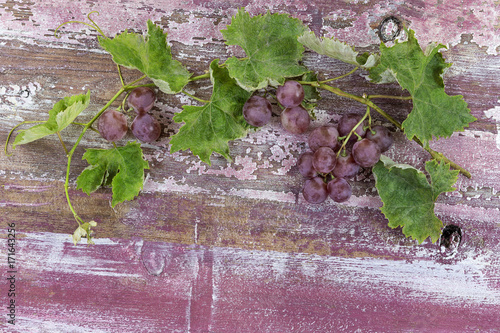 Bunch of red grapes on old rustic purple paint wooden table photo