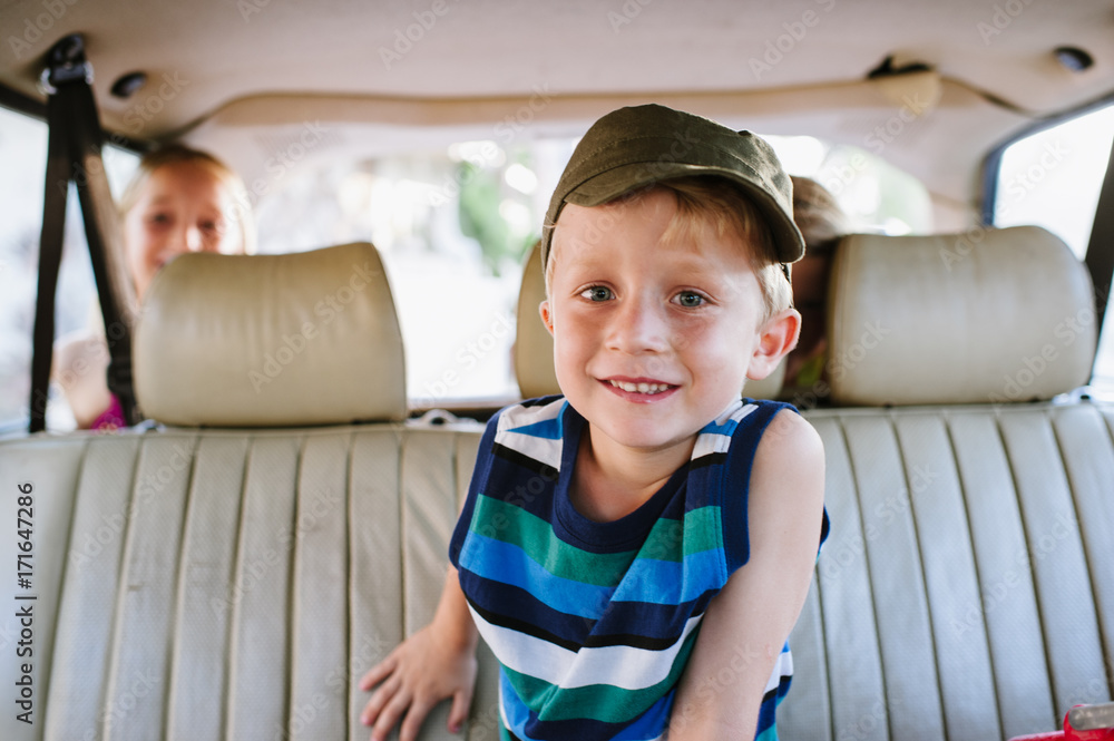 Young cute boy smiling sitting in backseat of car Stock Photo Adobe Stock