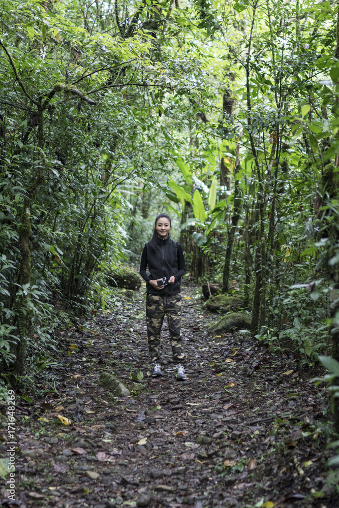 Hiker with a camera standing in the rain forest Hiker with a camera standing in the rain forest