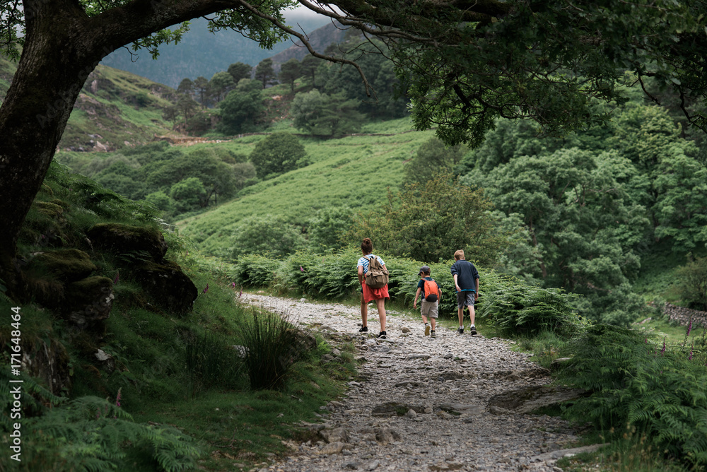 three kids walking on path in the mountain three kids walking on path in the mountain