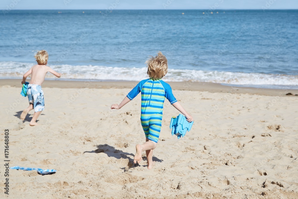 Children having fun playing on the beach together Children having fun playing on the beach together