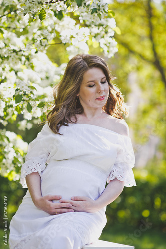 A pregnant girl on the background of the spring flowering trees 8210.