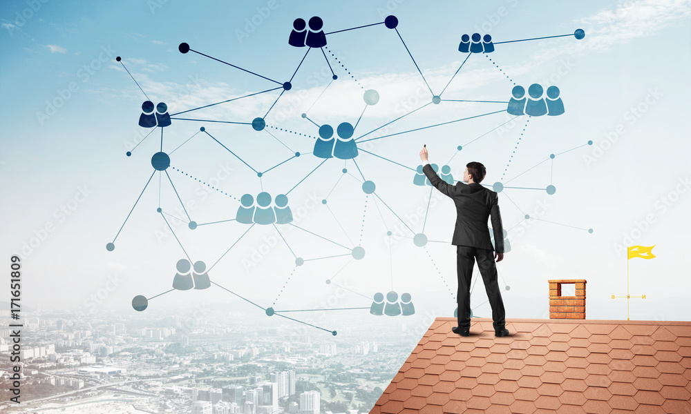 Businessman on house roof presenting networking and connection concept. Mixed media Businessman on house roof presenting networking and connection concept. Mixed media