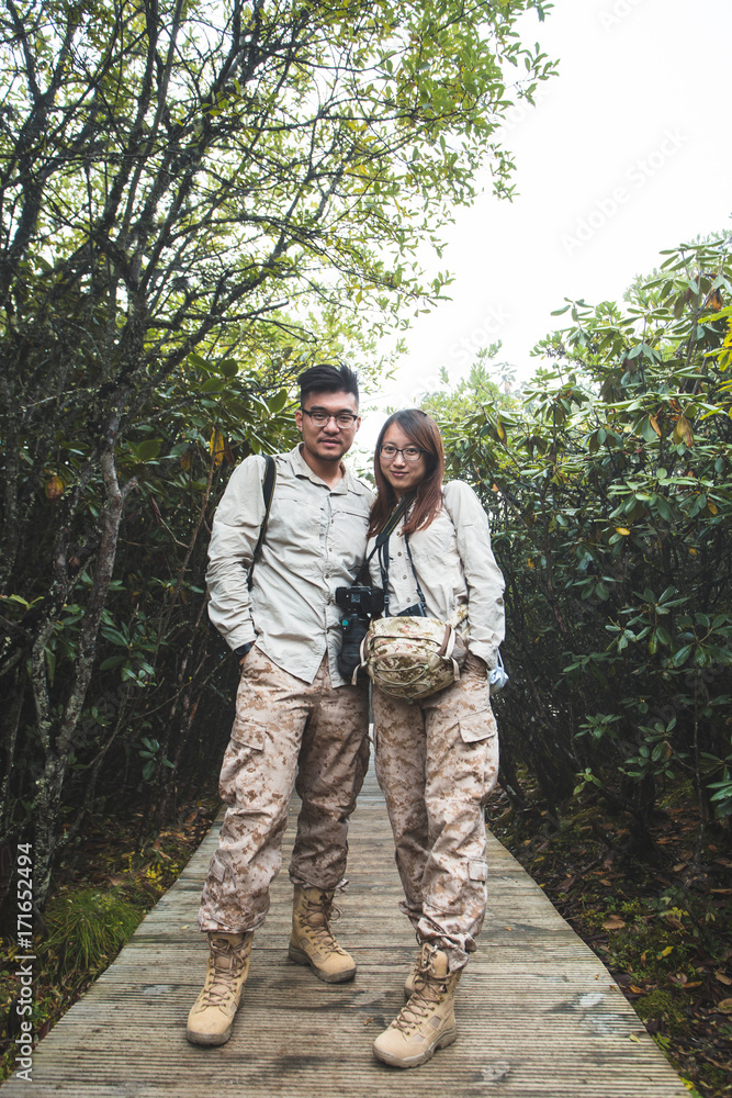 Young couple standing on the wooden path Young couple standing on the wooden path