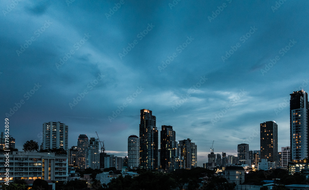 Dramatic cloud sky above city view in blue twilight