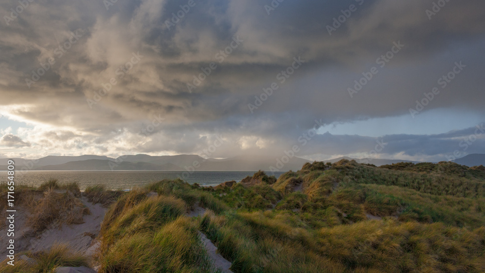 Gewitterwolken über Meer und Strand in Irland