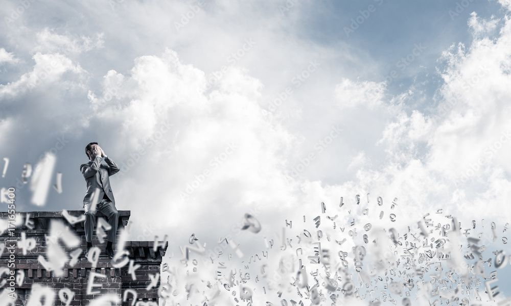 Obraz premium Young man on building edge do not want to see anything