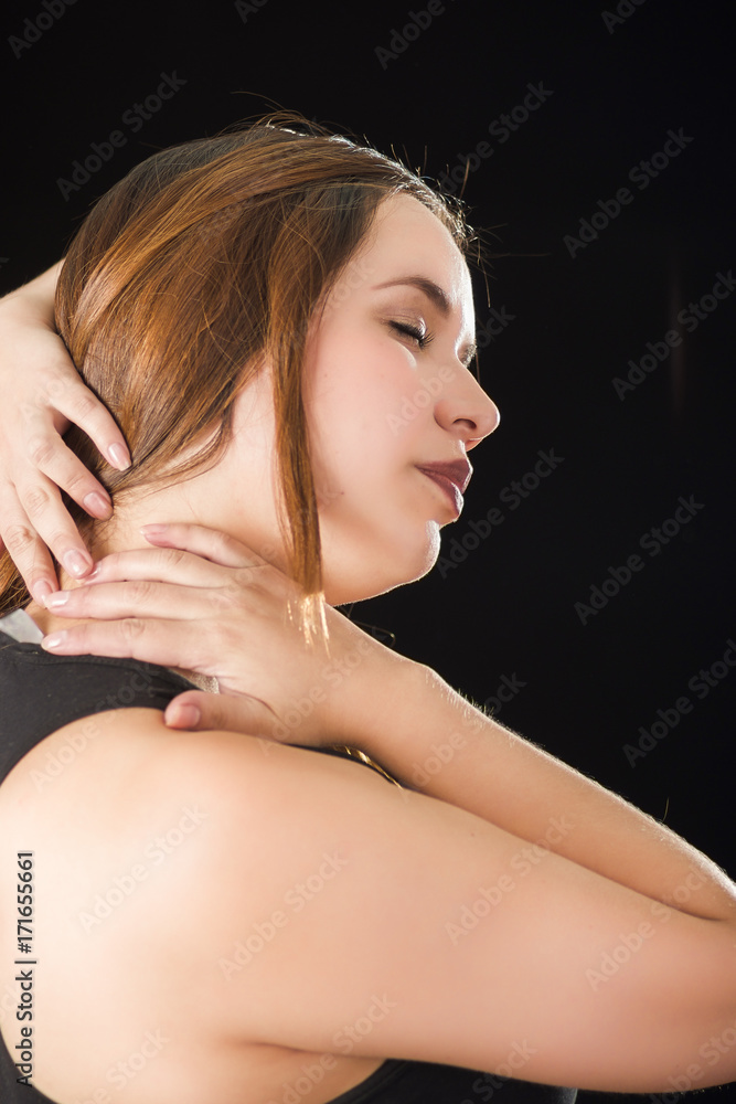 Fototapeta premium Close up of a beautiful young lady Suffer crick after workout in a black background
