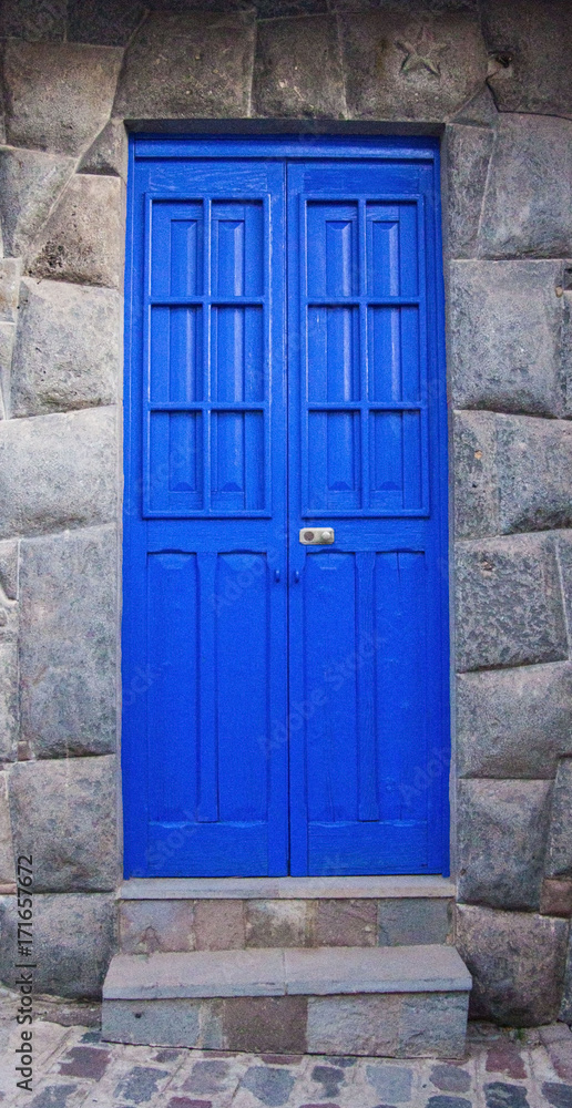 Puerta azul en cusco con piedras