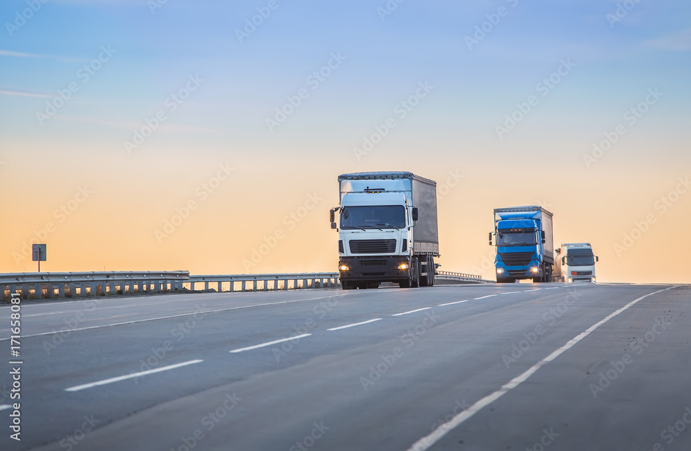 trucks goes on highway on sunset