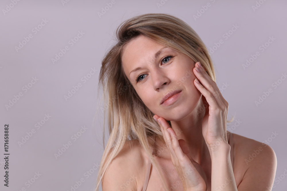 Beautiful Young Woman with Clean Fresh Soft Skin touching her face and enjoying Facial treatment results. Cosmetology , beauty and spa concept Beautiful Young Woman with Clean Fresh Soft Skin touching her face and enjoying Facial treatment results. Cosmetology , beauty and spa concept
