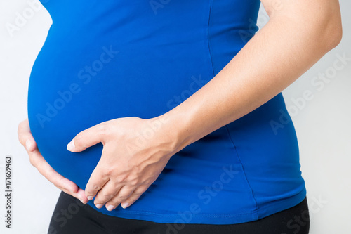 pregnant woman holding hands on her belly